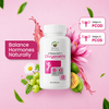 A white bottle of Prakriti Divyasakhi herbal capsules for women's health, displayed on a pink background with decorative flowers, green grapes, and text overlays indicating benefits for PCOD and PCOS.